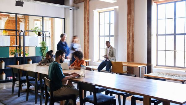 Adults collaborating at a table in a bright workspace